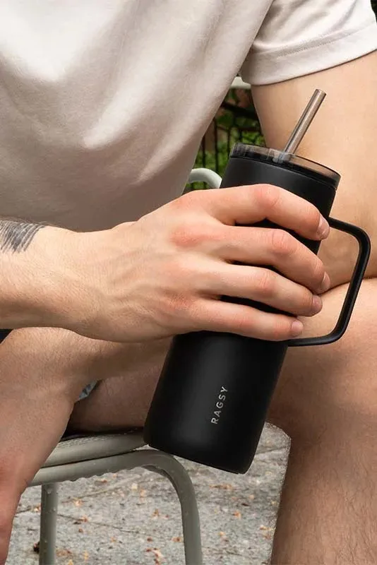 Moteris geria iš juodo MOSHI Tumbler per šiaudelį
