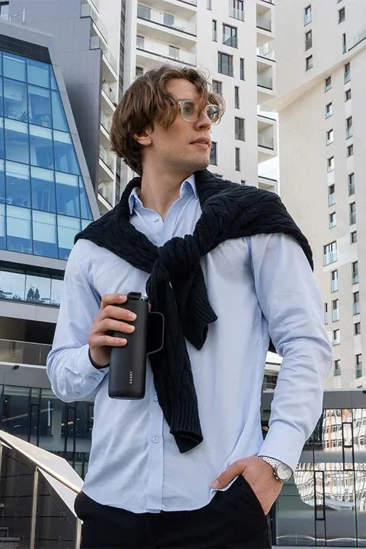 Juodas MOSHI Tumbler laikomas rankoje