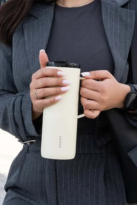 Smėlinis MOSHI Tumbler laikomas rankoje